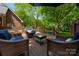Deck featuring cushioned seating and a glass top coffee table with wooded backyard views at 2382 Erika Ln, Gastonia, NC 28056
