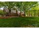 Green backyard with trees and the deck of a beautiful brick home at 2382 Erika Ln, Gastonia, NC 28056