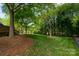 Expansive backyard featuring mature trees and lush lawn at 2382 Erika Ln, Gastonia, NC 28056