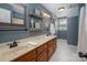 Spacious bathroom featuring double sinks with bronze faucets, warm wood cabinets, and decorative shelving at 2382 Erika Ln, Gastonia, NC 28056