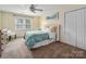 Cozy bedroom featuring a ceiling fan, a double window, a bed with decorative pillows, and a double closet with white doors at 2382 Erika Ln, Gastonia, NC 28056