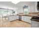 Well-lit kitchen featuring white cabinets, stone tile flooring, and a sunny breakfast nook at 2382 Erika Ln, Gastonia, NC 28056
