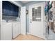 Functional laundry room features blue cabinets, washer, dryer, geometric backsplash, and access door at 2382 Erika Ln, Gastonia, NC 28056