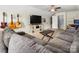 Living room featuring an extra large gray sectional sofa, a television, and decorative guitars mounted on the wall at 2382 Erika Ln, Gastonia, NC 28056