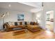 Bright living room with hardwood floors, large sofa, and a view into the kitchen at 2382 Erika Ln, Gastonia, NC 28056
