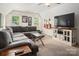 Living room with an extra large gray sectional sofa, two windows, and a television mounted on the wall at 2382 Erika Ln, Gastonia, NC 28056