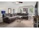 Living room with an extra large gray sectional sofa, two windows, and a television on a small white cabinet at 2382 Erika Ln, Gastonia, NC 28056