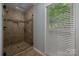 Modern tiled shower with a glass door and a window letting in natural light at 2382 Erika Ln, Gastonia, NC 28056