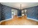 Open-concept dining room featuring decorative wallpaper and seamless flow into the adjacent kitchen at 2400 Commonwealth Ave, Charlotte, NC 28205