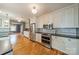 Bright kitchen with white cabinets, stainless steel appliances, hardwood floors, and subway tile backsplash at 2400 Commonwealth Ave, Charlotte, NC 28205