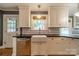 A kitchen with white cabinets, black countertops, stainless steel appliances, and a white farmhouse sink at 2400 Commonwealth Ave, Charlotte, NC 28205