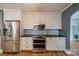 A kitchen showcasing white cabinets, black countertops, stainless steel appliances, and hardwood floors at 2400 Commonwealth Ave, Charlotte, NC 28205