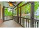 Inviting screened porch with wooden floors, ceiling fan, and views of the home's beautiful surrounding greenery at 2400 Commonwealth Ave, Charlotte, NC 28205