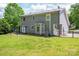 View of the home's rear exterior with a covered patio, lush lawn, and access to the fenced yard at 2439 Caswell Ct, Gastonia, NC 28054