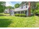 Attractive home featuring gray siding, brick chimney, and a lush green lawn with trimmed shrubbery at 2439 Caswell Ct, Gastonia, NC 28054