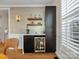 Stylish bar area with dark cabinets, open shelving, beverage cooler, and decorative wallpaper at 246 Mcduffie Ln, Fort Mill, SC 29715