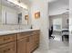 Well-lit bathroom showcasing wood cabinets, solid countertops, and an open doorway to the bedroom at 246 Mcduffie Ln, Fort Mill, SC 29715