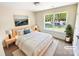 Comfortable bedroom with a large window, neutral decor, and virtually staged with a bed and side tables at 2512 Captains Watch Ne Rd, Kannapolis, NC 28083