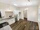 Well-lit kitchen with white cabinets, stainless appliances, and hardwood flooring at 2512 Captains Watch Ne Rd, Kannapolis, NC 28083