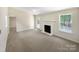 Sunlit living room featuring a cozy fireplace, neutral decor, and a door leading to the outside at 2512 Captains Watch Ne Rd, Kannapolis, NC 28083