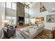 Open-concept living room with a stone fireplace, hardwood floors, and large windows offering ample natural light at 288 Ridge Reserve Dr, Lake Wylie, SC 29710