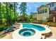 The beautiful pool and hot tub are surrounded by lush trees, patios, retaining walls and seating at 288 Ridge Reserve Dr, Lake Wylie, SC 29710