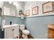 Charming powder room with floral wallpaper, blue wainscoting, and decorative mirror at 288 Ridge Reserve Dr, Lake Wylie, SC 29710