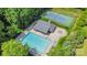 Aerial view of a community pool and tennis court surrounded by lush greenery, perfect for recreation at 3005 Sandbox Cir, Indian Trail, NC 28079
