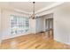 Elegant dining room with hardwood floors, wainscoting, and a chandelier, adjacent to the foyer at 3005 Sandbox Cir, Indian Trail, NC 28079
