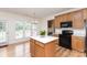 Eat-in kitchen area featuring wood cabinets, black appliances, and island with seating at 3005 Sandbox Cir, Indian Trail, NC 28079