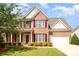 Charming two-story brick home featuring a well-manicured lawn, red shutters and a two-car garage at 3005 Sandbox Cir, Indian Trail, NC 28079