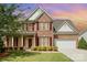 Charming two-story brick home featuring a well-manicured lawn, red shutters and a two-car garage at 3005 Sandbox Cir, Indian Trail, NC 28079