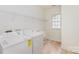 Laundry room features white washer and dryer, utility sink, and wire shelving at 3005 Sandbox Cir, Indian Trail, NC 28079