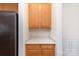 Kitchen pantry area with wood cabinets, drawers, and black appliances at 3005 Sandbox Cir, Indian Trail, NC 28079