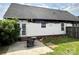 Rear view of a fire-damaged house with white siding, patio, and partially fenced yard at 3205 Creek Trail Rd, Indian Trail, NC 28079