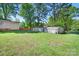 Green backyard featuring a storage shed and a mix of trees, with ample space for outdoor activities at 3265 W Innes St, Salisbury, NC 28144