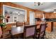 Dining room with wood-paneled walls, vintage table set with chairs, and connecting to a kitchen with cabinets at 3265 W Innes St, Salisbury, NC 28144