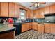 Compact kitchen with vintage wood cabinets, black countertop and flooring at 3265 W Innes St, Salisbury, NC 28144