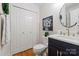 Bathroom features a vanity with a black cabinet, a white countertop and a toilet adjacent to a linen closet at 4027 Wallbrook Dr, Matthews, NC 28105