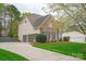 Side view showcasing home's brick accents, three-car garage, and well-maintained landscaping on a verdant lawn at 4027 Wallbrook Dr, Matthews, NC 28105