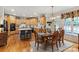 Spacious kitchen with stainless appliances, an island with seating, and a dining area with an elegant chandelier at 4027 Wallbrook Dr, Matthews, NC 28105