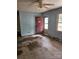A vacant living room with outdated ceiling fan, blue walls, and exterior access at 4406 Valeview Ln, Charlotte, NC 28269