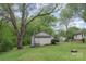 Cozy backyard featuring a well-maintained lawn, a firepit, and a building with steps leading to a door at 500 3Rd St, Stanley, NC 28164