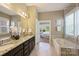Elegant primary bathroom featuring double vanity, soaking tub, and glass-enclosed shower at 505 Chamberlain Ct, Mcadenville, NC 28101