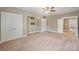 Spacious bedroom with neutral carpet, ceiling fan, and multiple closets and doors at 505 Chamberlain Ct, Mcadenville, NC 28101