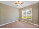 Neutral bedroom featuring plush carpet, ceiling fan, and ample natural light from a large window at 505 Chamberlain Ct, Mcadenville, NC 28101