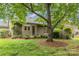 Backyard featuring a lush lawn, mature trees, and access to the home with sliding glass doors at 5306 Sandtrap Ln, Charlotte, NC 28226