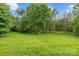 Expansive backyard with a lush green lawn bordered by mature trees, providing a tranquil and private setting at 5306 Sandtrap Ln, Charlotte, NC 28226