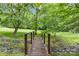Beautiful backyard featuring a charming wooden bridge and lush landscaping, creating a peaceful outdoor retreat at 5306 Sandtrap Ln, Charlotte, NC 28226