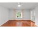 Spacious bedroom with hardwood floors, a ceiling fan, and a window providing natural light at 5306 Sandtrap Ln, Charlotte, NC 28226